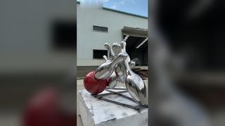 The mirrored stainless steel bowling sculpture vividly captures the dynamic moment 